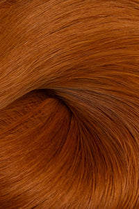A close-up texture shot of warm coppery auburn hair, showing the fine strands and glossy sheen of the hair product. (Cowgirl Copper / #180)