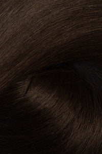 A close-up texture shot of dark brown hair, showing the fine strands and subtle sheen. (Soft Black / #1b)