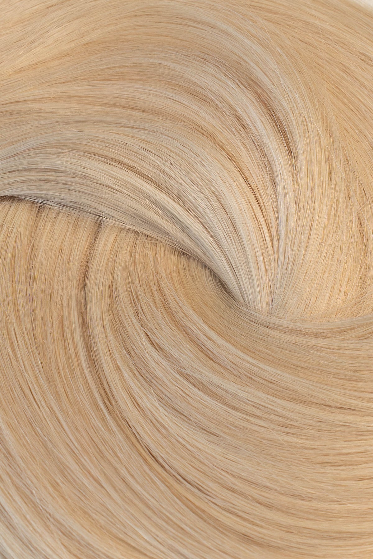 A close-up of light blonde hair strands arranged in a soft spiral pattern, showing the texture and color of the hair.  (Ice Blondest / #24A)