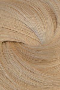 A close-up texture shot of light blonde hair, showing the fine strands and subtle golden-beige tones arranged in a soft swirl. (Blondest Blonde / #60)