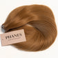 A bundle of PHANES hair extensions in a warm auburn-brown shade, arranged in a loose curl with a beige brand tag attached, on a plain white background. (Caramel / #8)
