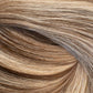 A close-up texture shot of wavy hair with a blend of light brown, golden blonde, and dark brown tones. (Boston Balayage B2/60)