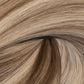 A close-up texture shot of wavy hair in a light ash blonde color with subtle brown and beige highlights. (Ash Piano / FV)