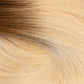 A close-up texture shot of straight hair with a warm blonde to light brown ombré color transition. (Rooted Blonde / #T4/60)