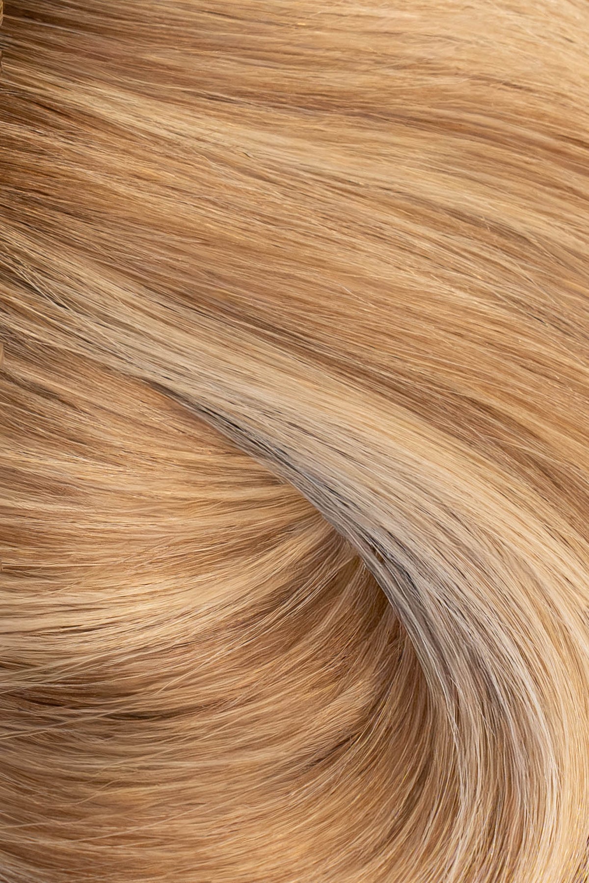 A close-up texture shot of wavy, light golden blonde hair with subtle warm brown and beige undertones. (Brooklyn Balayage / #TFF)