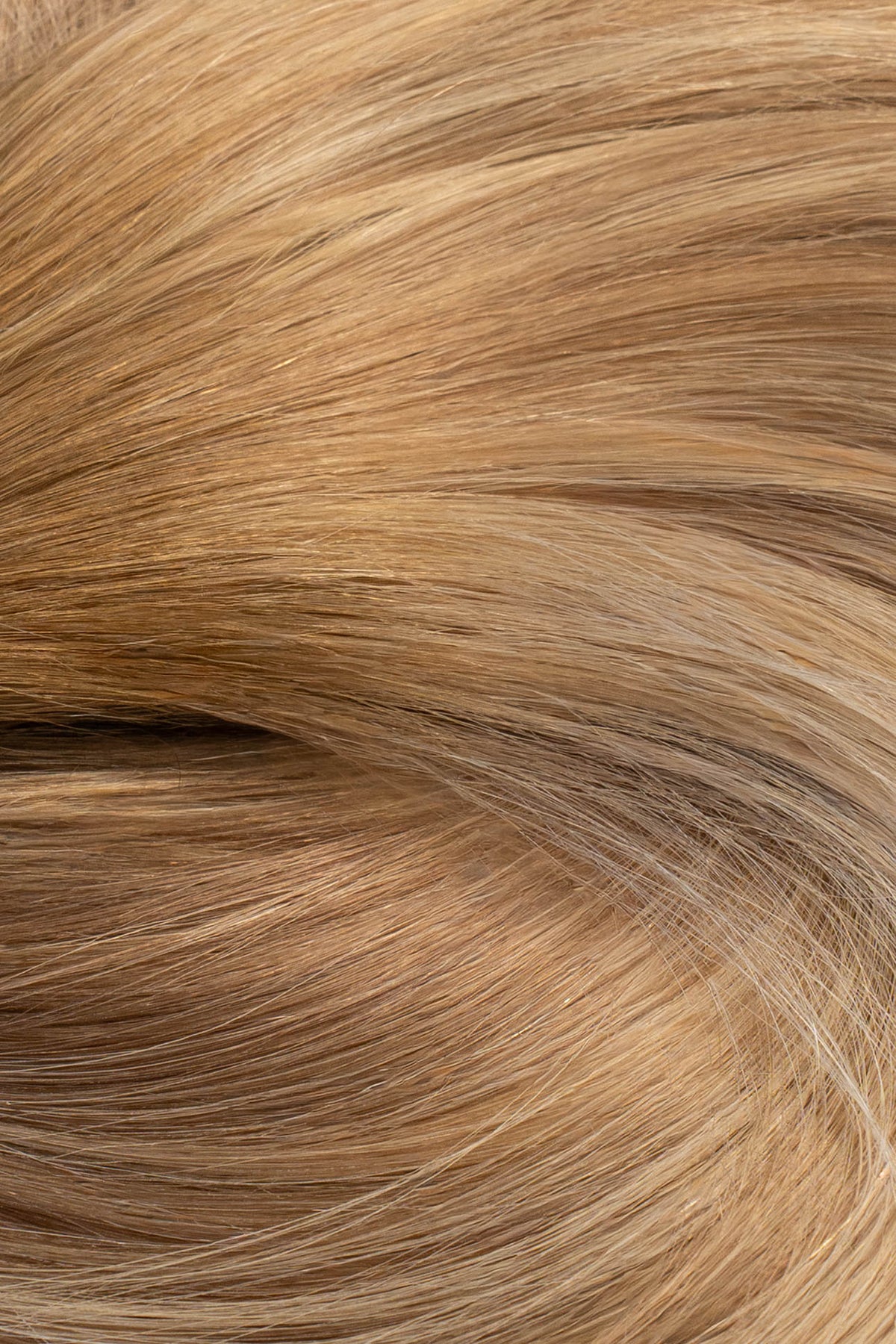 A close-up texture shot of light golden blonde hair with subtle warm brown and beige undertones. (Miami Balayage / TLQ)