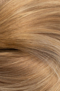 A close-up texture shot of light golden blonde hair with subtle warm brown and beige undertones. (Miami Balayage / TLQ)
