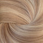 A close-up texture shot of light blonde hair styled in a spiral pattern, showing the fine strands and warm golden-blonde color. (Icy Balayage / #TSK)