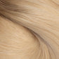A close-up texture shot of light blonde hair with subtle warm brown lowlights, showing the fine strands and smooth flow of the hair. (Cool Ombré / #TTA)